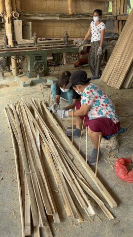 A group of workers put together the components of a bamboo structure.