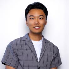 Cheng Chow Cheng Chow wears a grey button-down shirt and stands smiling in front of a white background.