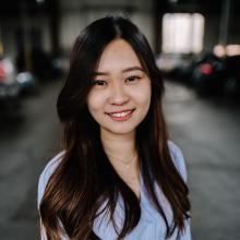 Andrea Lim A woman in a blue blouse smiles in a parking garage.