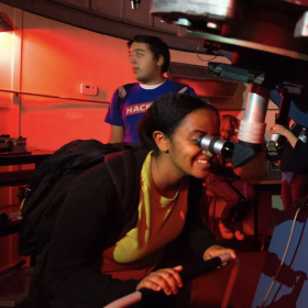 student looking at telescope