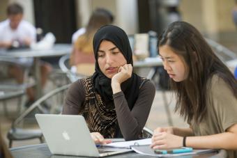 students sitting at table with computer